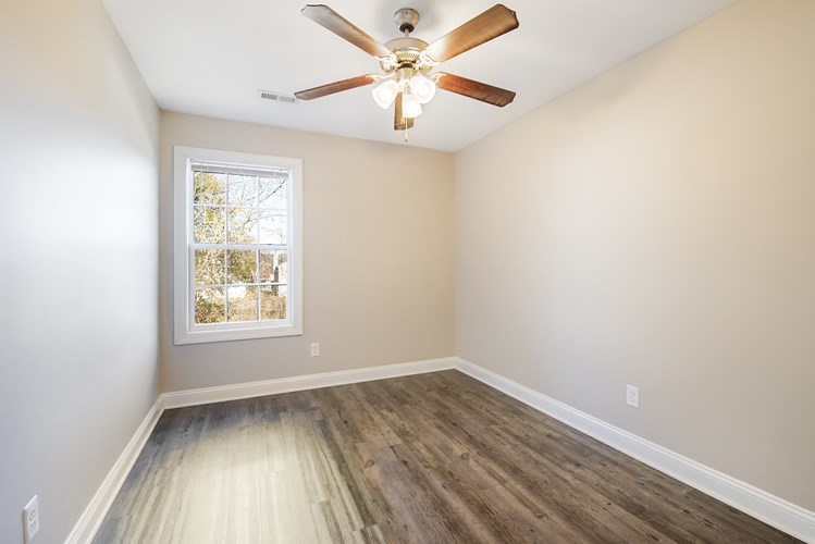 A room with a ceiling fan and a window.
