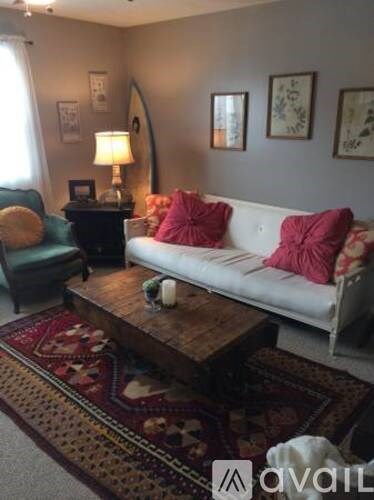 A living room with a white couch and a wooden coffee table.
