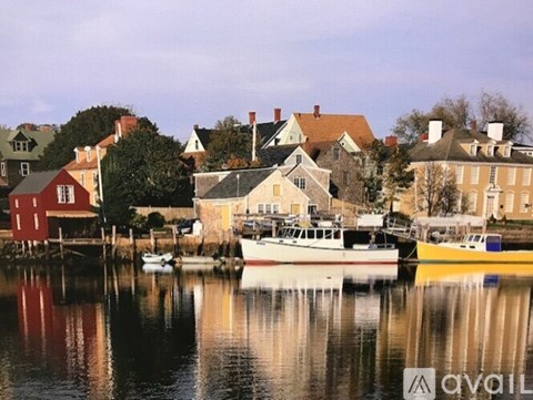 A boat is docked in front of a yellow building.