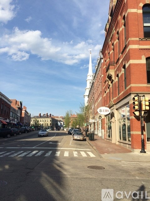 A street view with a church spire in the background.