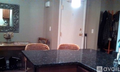 A kitchen with a black counter top and a mirror above it.