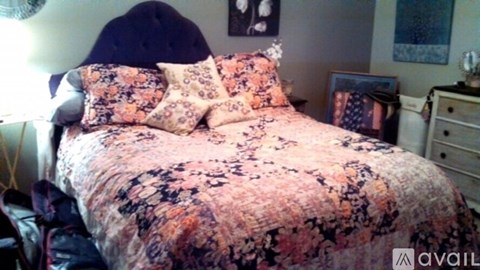 A bed with a floral patterned comforter and matching pillows.