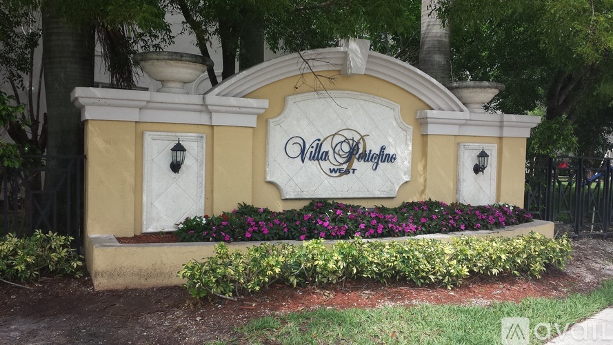 Villa Design sign in front of trees and flowers.