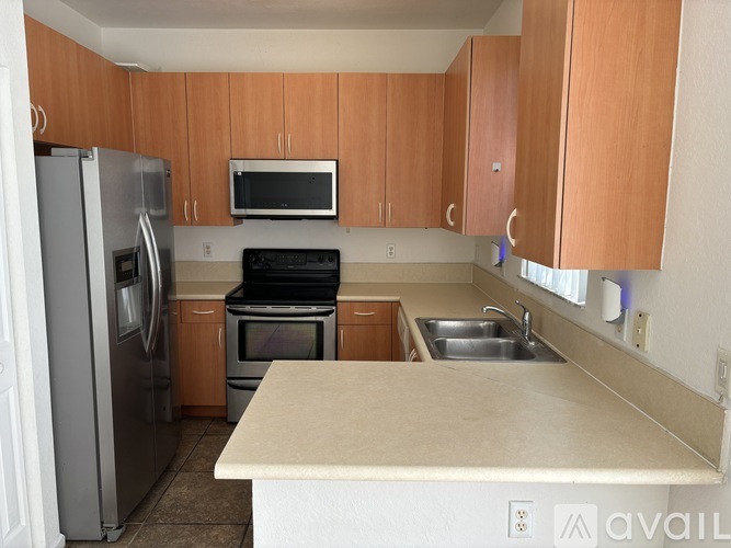 A kitchen with wooden cabinets and a white fridge.
