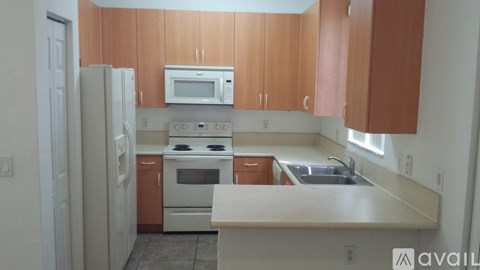 A kitchen with wooden cabinets and a white fridge.