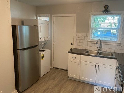 A kitchen with a refrigerator, dishwasher, and cabinets.
