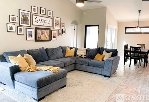 A living room with a grey sofa and a grey rug.