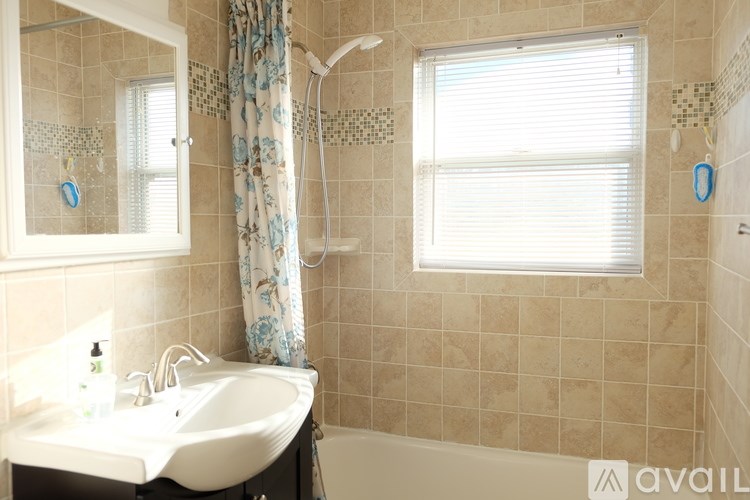 A bathroom with a white sink and a shower with a curtain.