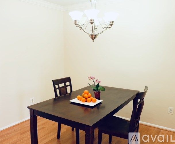 A dining table with a plate of oranges and a potted plant.
