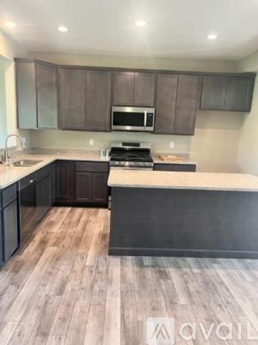A kitchen with dark wood cabinets and a light countertop.