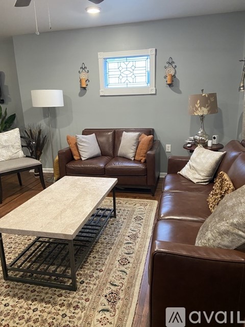 A living room with brown leather couches and a white coffee table.