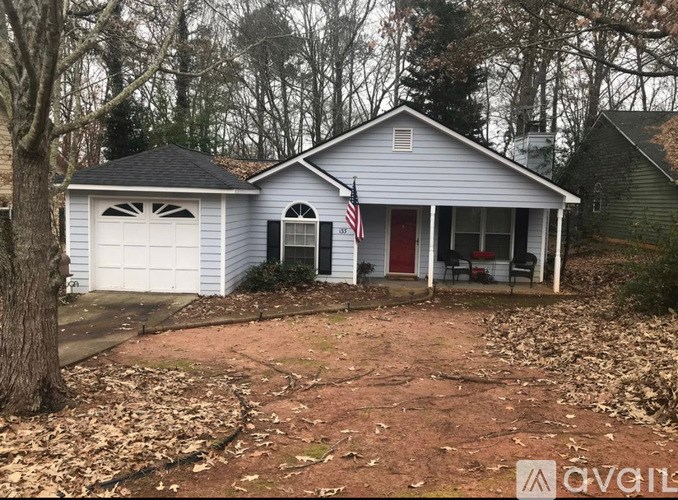 A house with a red door and an American flag on the front porch.