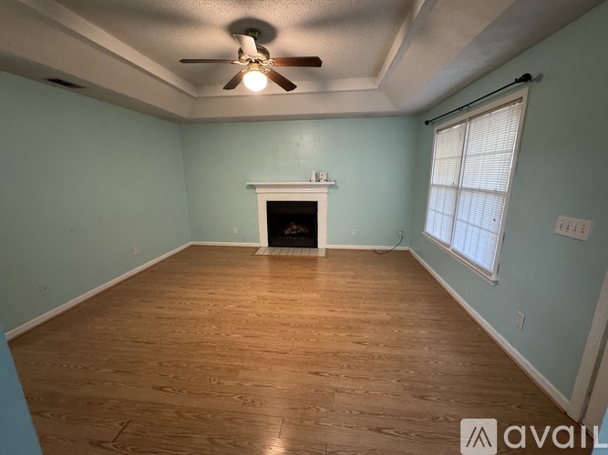 A bedroom with a bed, a chair, a dresser, and a window with blinds.
