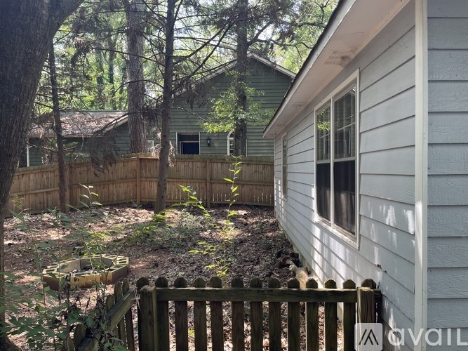 A house with a white siding and a wooden fence.