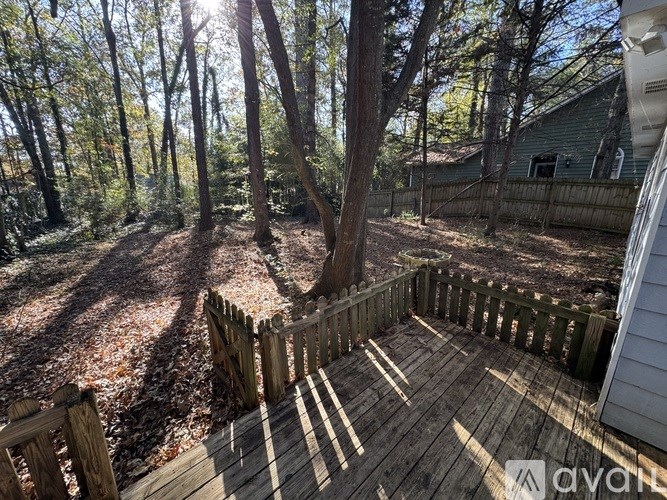 A forest scene with a wooden fence and trees.