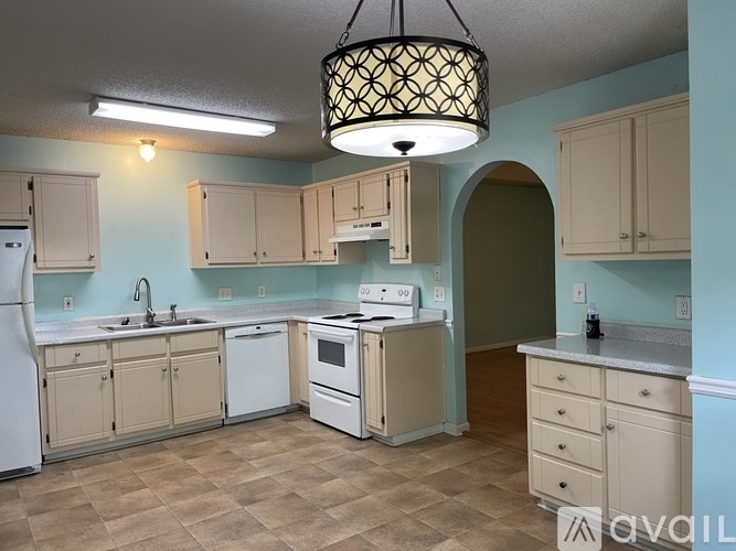 A kitchen with a white refrigerator, a white dishwasher, a white stove, and a white oven.