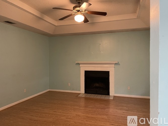A room with a fireplace and a ceiling fan.