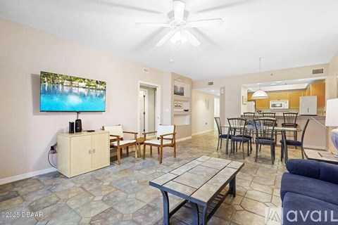 A living room with a ceiling fan and a painting of a pool.
