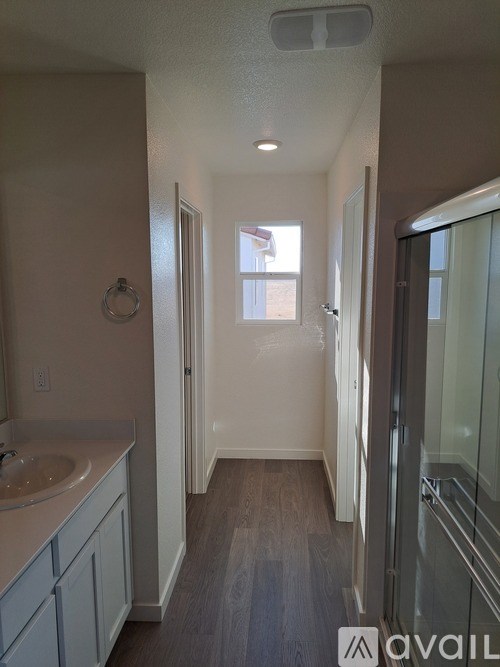 A bathroom with a sink, mirror, and shower.