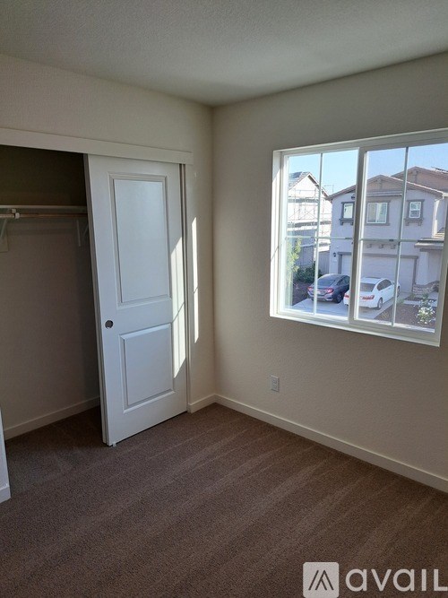 A room with a white door and a window showing a street view.