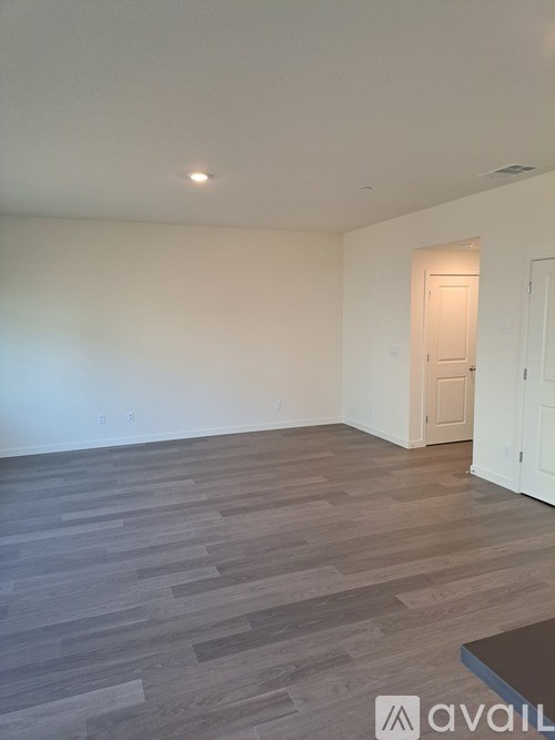 A room with wooden flooring and a white door.