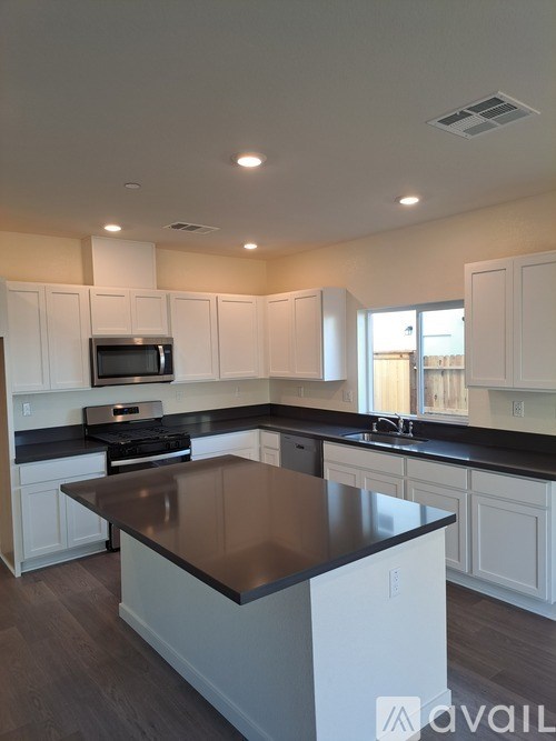 A kitchen with white cabinets and a black countertop.
