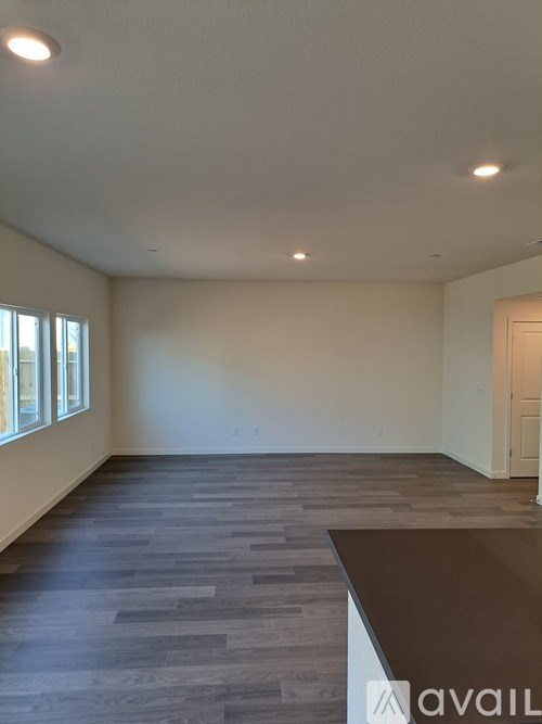 A room with a wooden floor and a white wall.