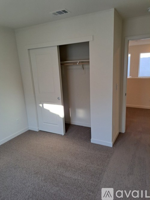 A room with a carpeted floor and a white door.