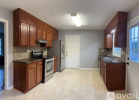 A kitchen with brown cabinets and a granite countertop.