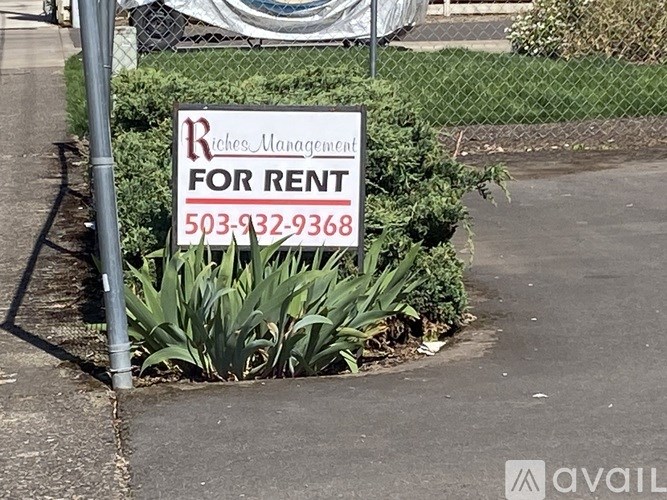 A sign for Riches Management for rent with a phone number on it.