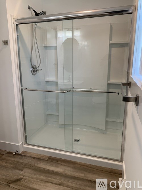 A glass shower stall with a silver frame and a glass door.