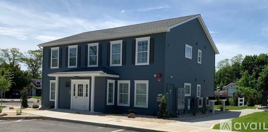 A blue house with a white door and windows.