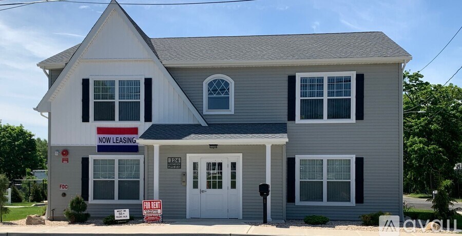 A two story house with a sign that says "Now Leasing".