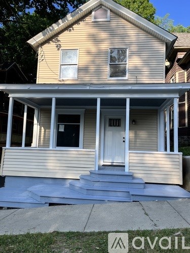 A two-story house with a white door and windows.
