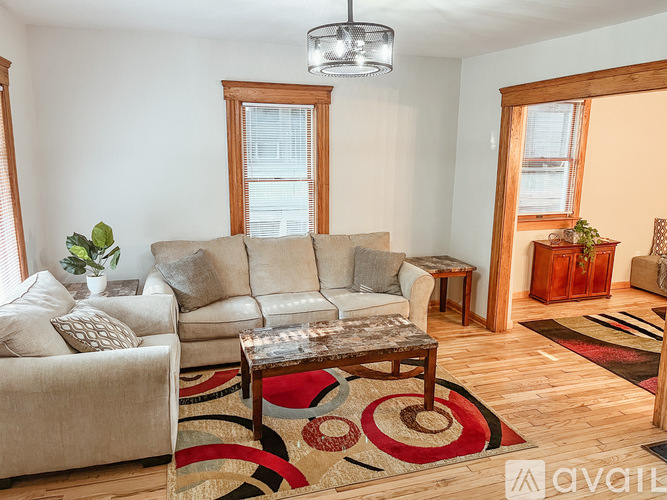 A living room with a grey couch, a coffee table, and a rug.