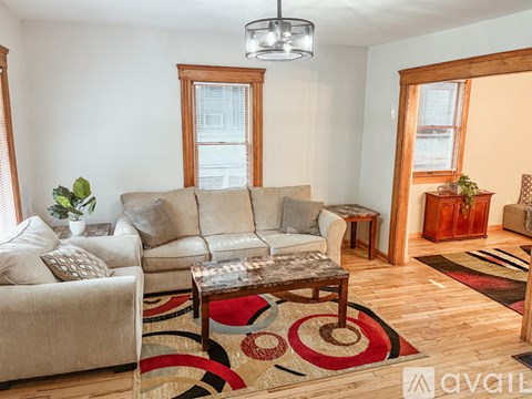 A living room with a grey couch, a coffee table, and a rug.