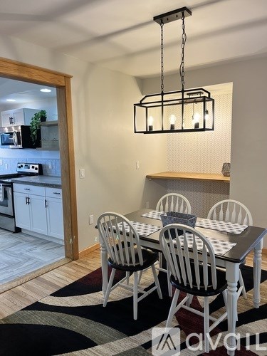 A dining room with a table and chairs.