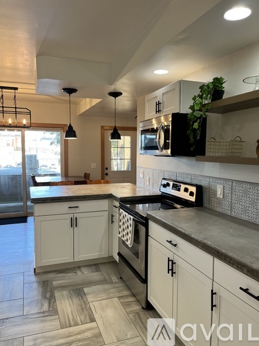 A kitchen with a black oven and white cabinets.