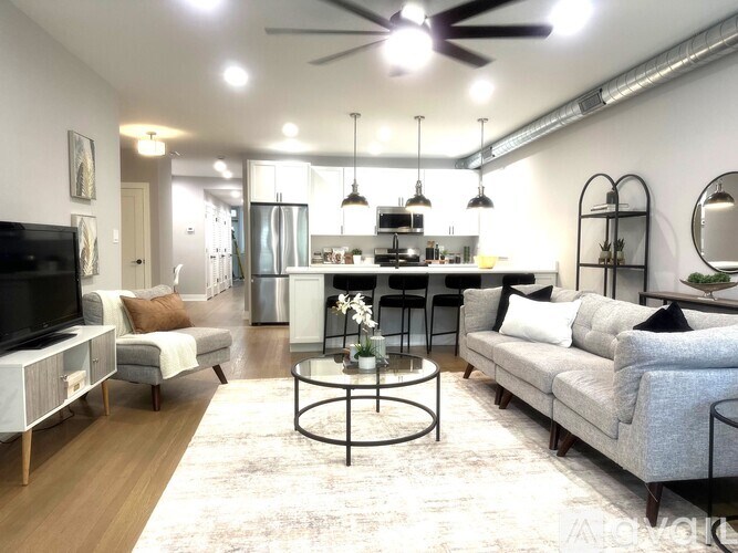 A modern living room with a grey sofa, a coffee table, and a television.