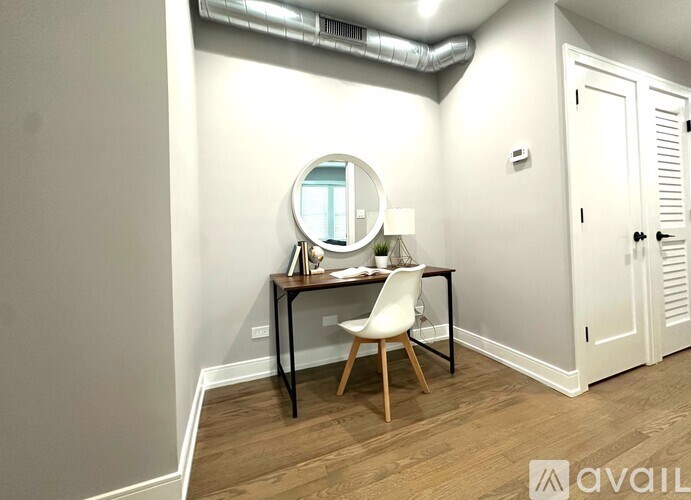 A room with a desk and chair and a mirror.