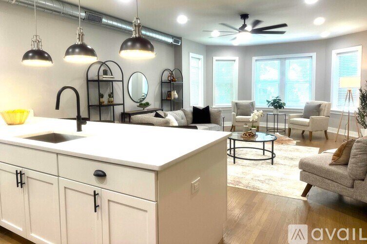 A modern kitchen with a large island and pendant lights.