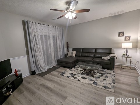 A living room with a black sofa and a television.