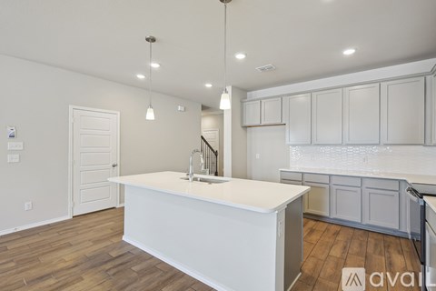 A kitchen with white cabinets and a white island.