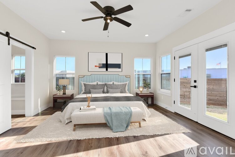 A bedroom with a large bed and a ceiling fan.
