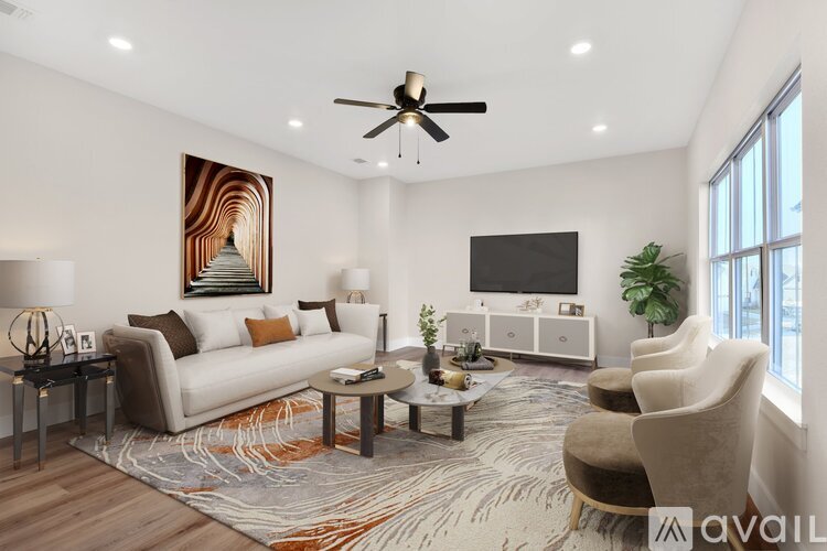 A living room with a couch, chairs, a coffee table, and a television.
