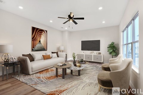 A living room with a couch, chairs, a coffee table, and a television.
