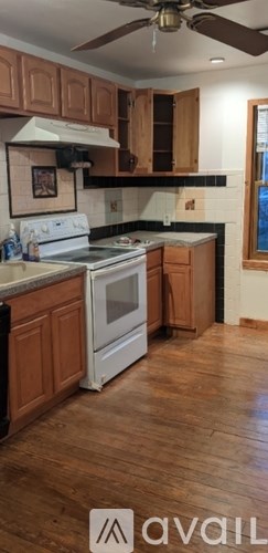 A kitchen with wooden cabinets and a white stove top oven.