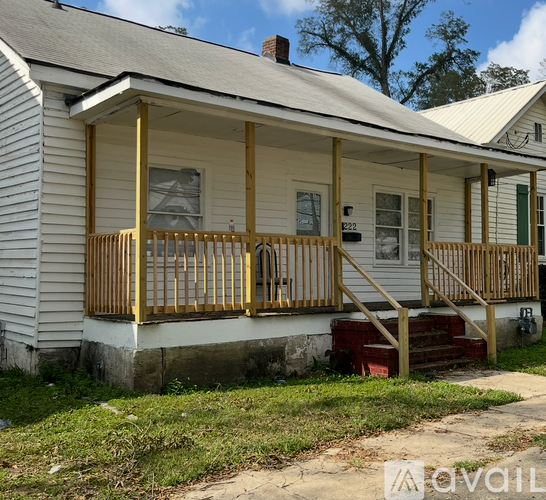 A white house with a yellow porch.