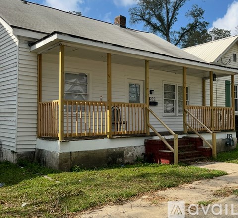 A white house with a yellow porch.
