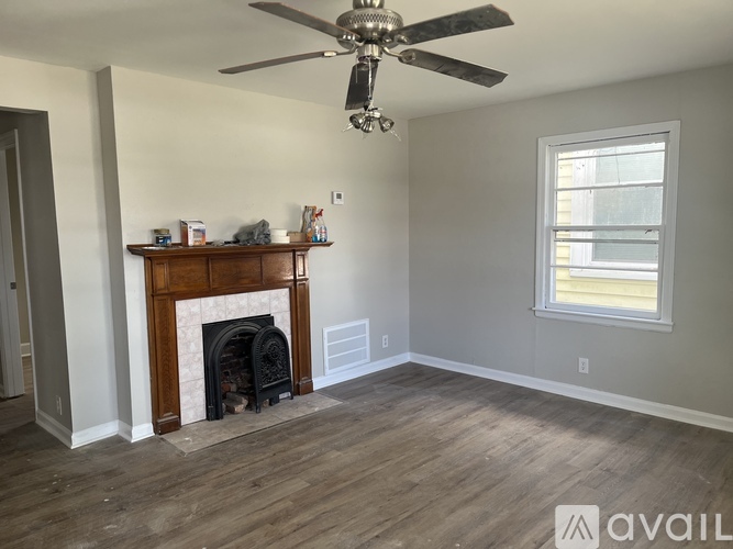 A room with a fireplace and a ceiling fan.